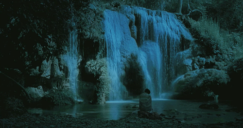 animated gif of waterfall with person sitting facing towards waterfall